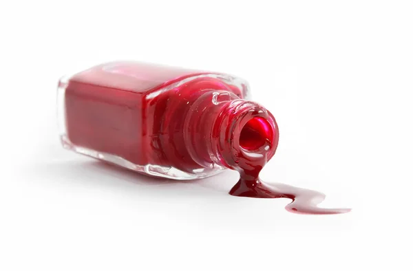 stock image Red nail polish pouring from overturned bottle