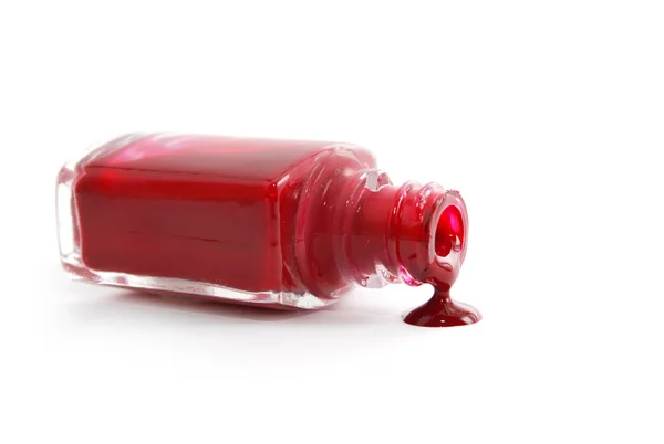 stock image Red nail polish pouring from overturned bottle