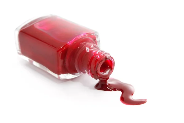 stock image Red nail polish pouring from overturned bottle