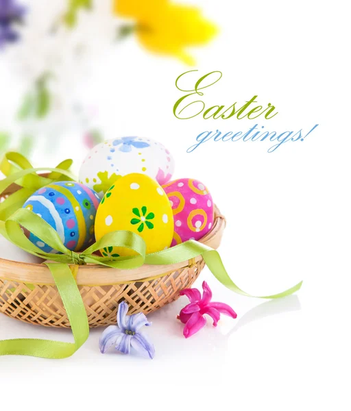 Huevos de Pascua en cesta con lazo Imágenes de stock libres de derechos