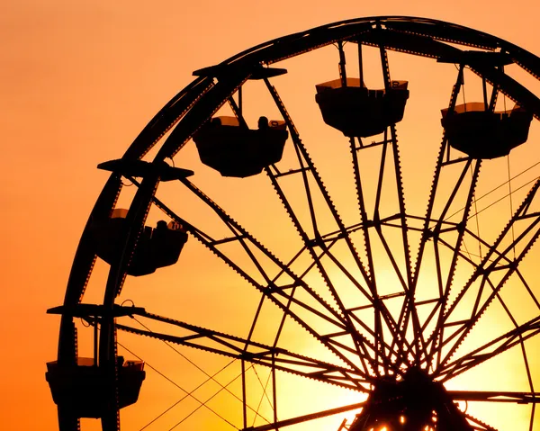 Silhouette of ferris wheel at sunset at county fair. — Stock Photo, Image