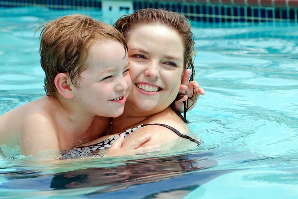 Mère et fils se rafraîchissent en jouant dans la piscine pendant la chaude journée d'été — Photo
