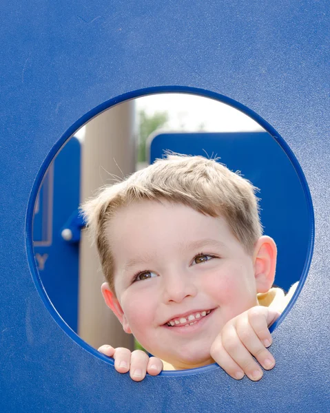 Симпатичный дошкольник играет на детской площадке — стоковое фото