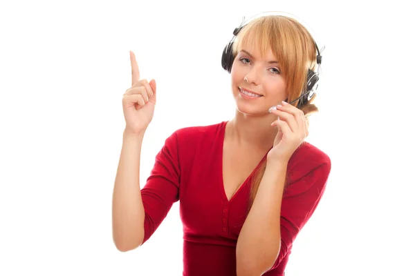 युवा महिला हेडफ़ोन में लाइन ऑपरेटर की मदद करती है और एक उंगली दिखाती है — स्टॉक फ़ोटो, इमेज