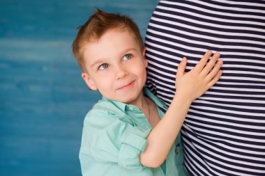 Child Listening to pregnant woman's stomach clipart