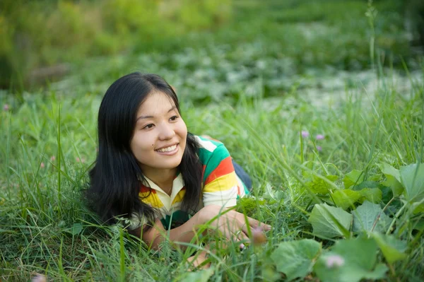 stock image Smiling woman laying on grass