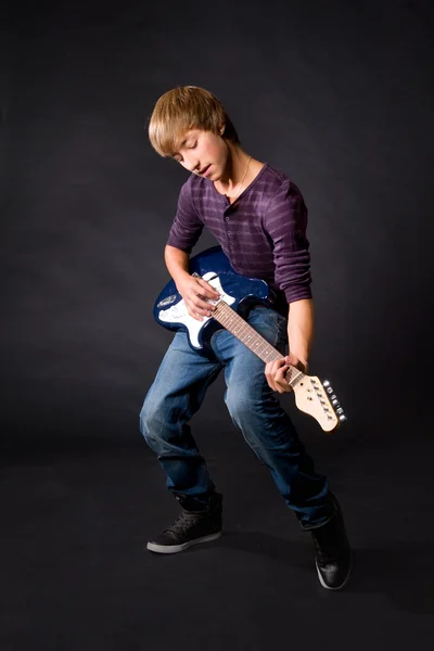 Genç adam gitar koyu arka plan üzerinde oynama Telifsiz Stok Imajlar