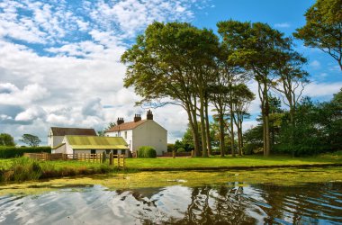 Whitewashed house next to a canal clipart