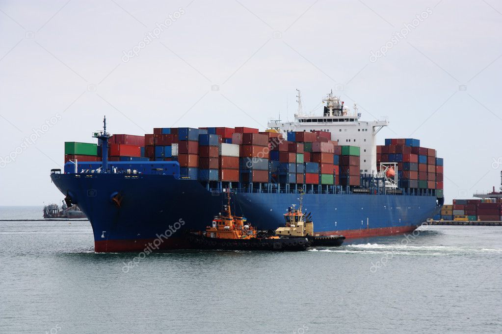 Tugboats pulling container vessel