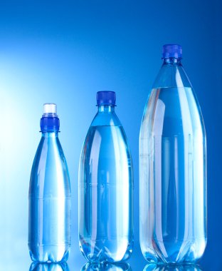 Grup plastik şişe su mavi zemin üzerine