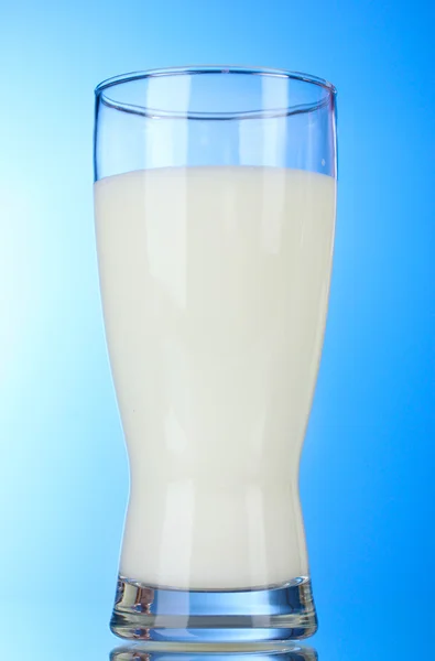 Smakelijke melk in glazen op blauwe achtergrond — Stockfoto