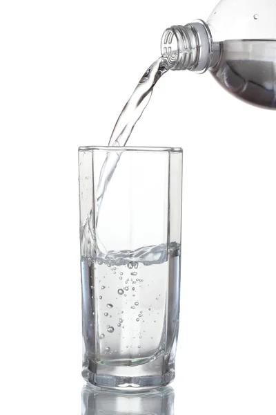 Versare acqua su vetro isolato su bianco — Foto Stock