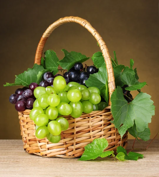 Ripe grapes in a basket on yellow background — Stock Photo, Image