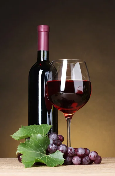 Glas wijn, fles en druiven op gele achtergrond — Stockfoto