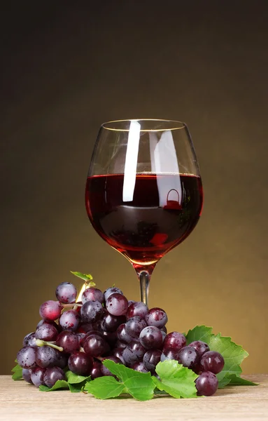 Glass of wine and grapes on yellow background — Stock Photo, Image