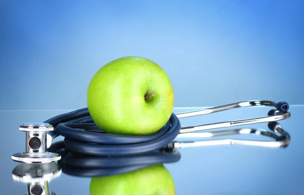 Stetoskop a zelené jablko — Stock fotografie