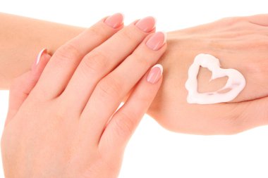 Two woman hands spreading the cream in the form oh heart isolate clipart