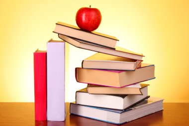 Books pile on the table and yellow background clipart