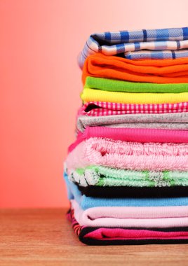 Pile of colorful clothes over red background clipart