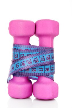 pembe dumbell ve beyaz zemin üzerine şerit metre