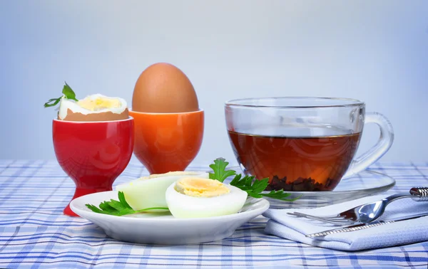 Lækker morgenmad med kogte æg og te - Stock-foto
