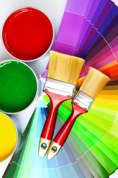 Open tin cans with paint, brushes and palette — Stock Photo, Image
