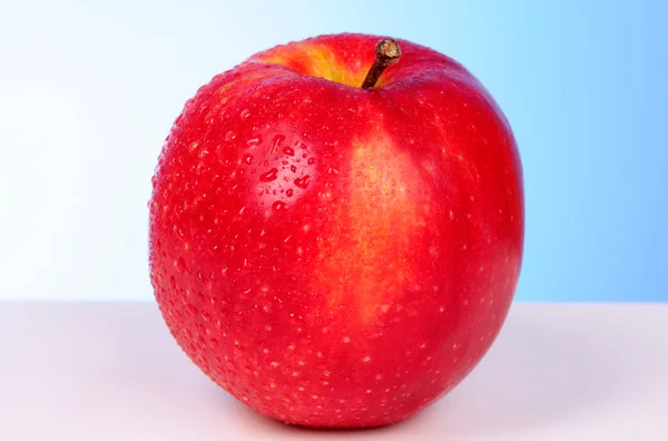 Rode appel op blauwe achtergrond — Stockfoto