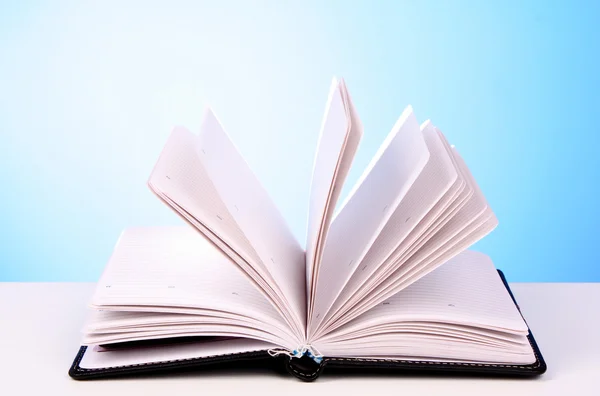 Branco livro aberto com páginas em branco sobre fundo azul — Fotografia de Stock