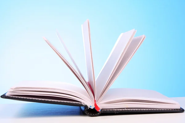 stock image White opened book with blank pages on blue background