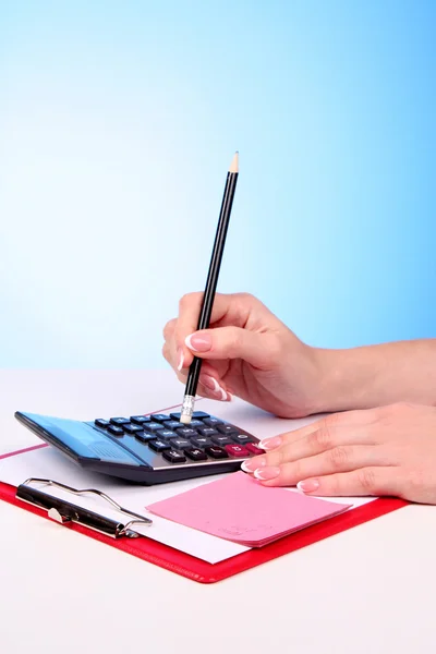 Closeup of a young woman hand calculating bills — Stock Photo, Image