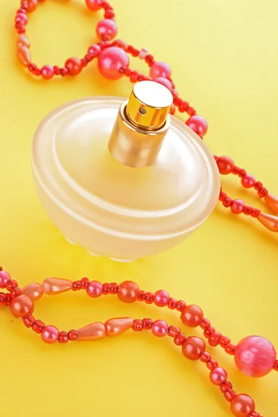 Láhev parfému na žlutém pozadí — Stock fotografie