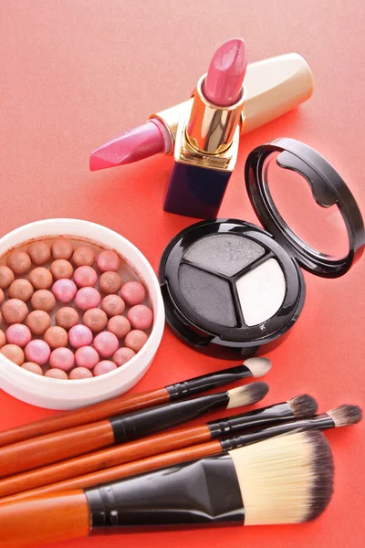 Mnoho kosmetiky na červeném pozadí — Stock fotografie