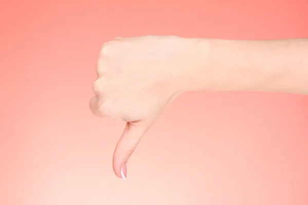 Woman hand with thumb down on red background — Stock Photo, Image