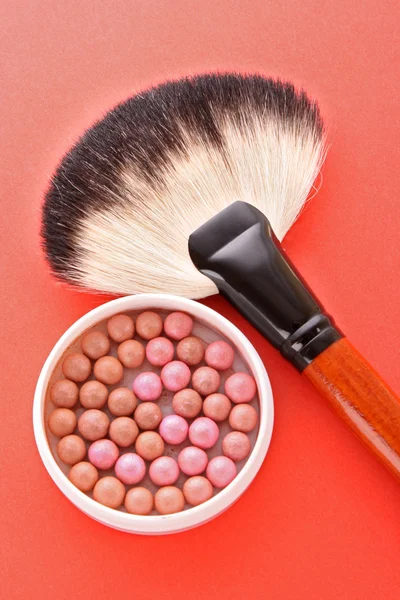 Cepillo cosmético y colorete en el fondo rojo —  Fotos de Stock