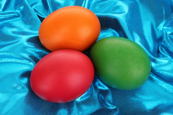 Цветные пасхальные яйца на текстильном фоне — стоковое фото