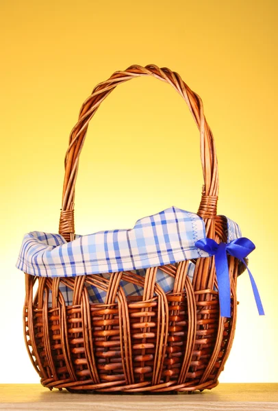 Wicker basket on yellow background — Stock Photo, Image