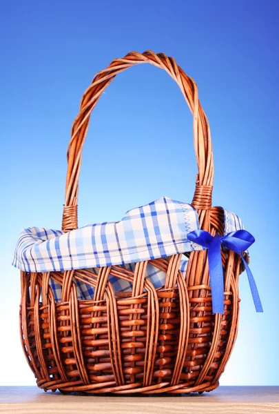 Wicker basket on blue background — Stock Photo, Image