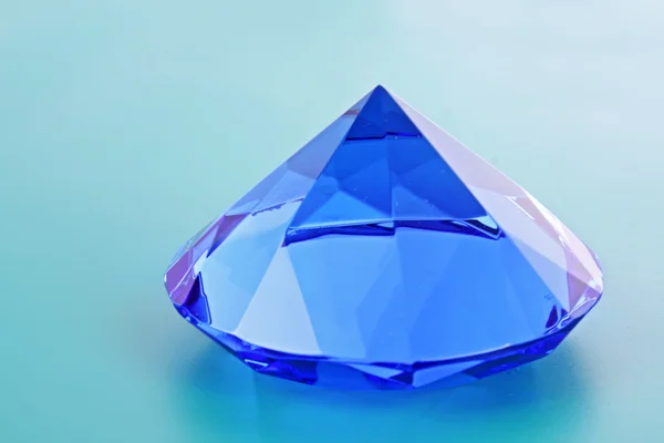 Na niebieskim tle z bliska niebieski diament — Zdjęcie stockowe