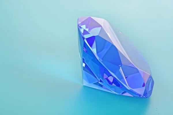 Nahaufnahme eines blauen Diamanten vor blauem Hintergrund — Stockfoto