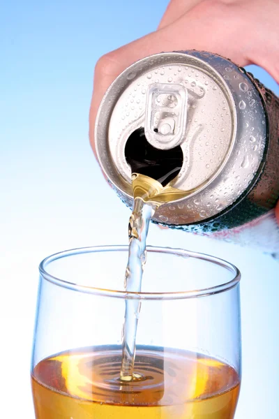 Alguém encha o copo com cerveja no fundo azul — Fotografia de Stock
