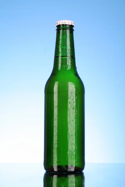 Flasche Bier auf blauem Hintergrund — Stockfoto