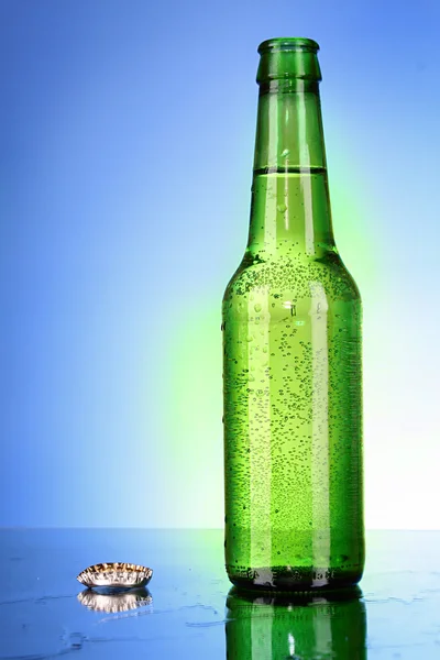 Botella de cerveza sobre fondo azul —  Fotos de Stock