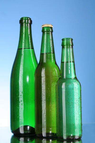 Garrafas de cerveja no fundo azul — Fotografia de Stock