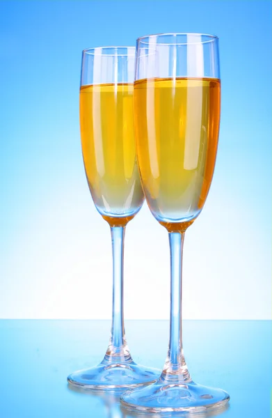 Copo com champanhe sobre fundo azul — Fotografia de Stock