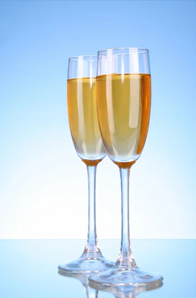 Bicchiere con champagne su sfondo blu — Foto Stock