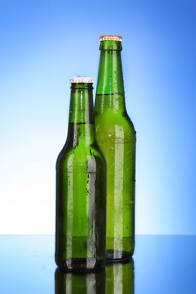 Láhev piva na modrém pozadí — Stock fotografie