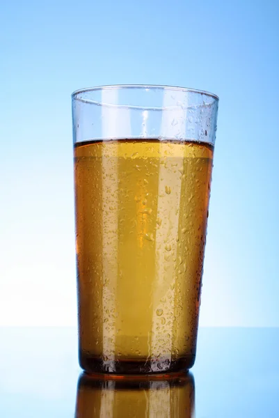 Tasse Bier auf blauem Hintergrund — Stockfoto