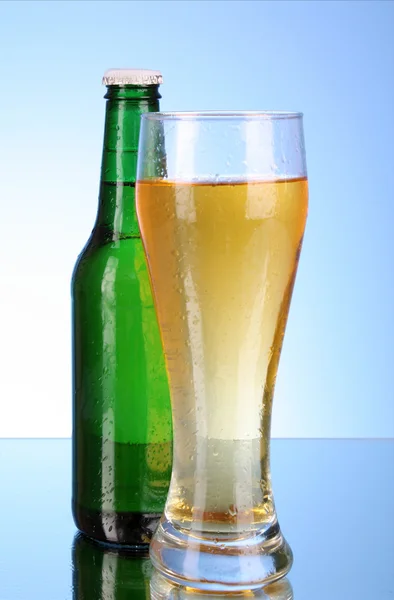 瓶用啤酒和蓝色背景上的杯子 — 图库照片
