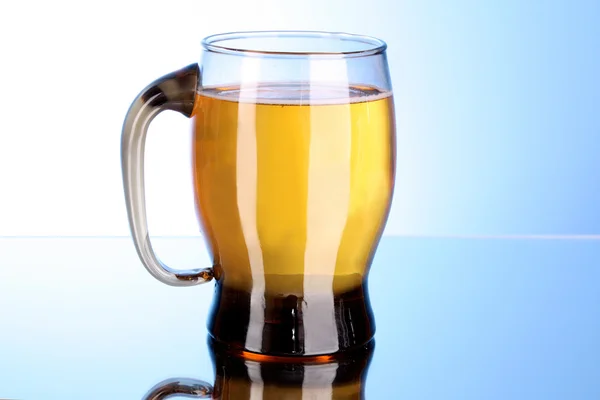 Mug of beer on blue background — Stock Photo, Image