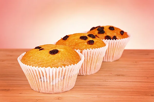 Muffins mit Rosinen auf hölzerner Oberfläche isoliert auf weiß — Stockfoto